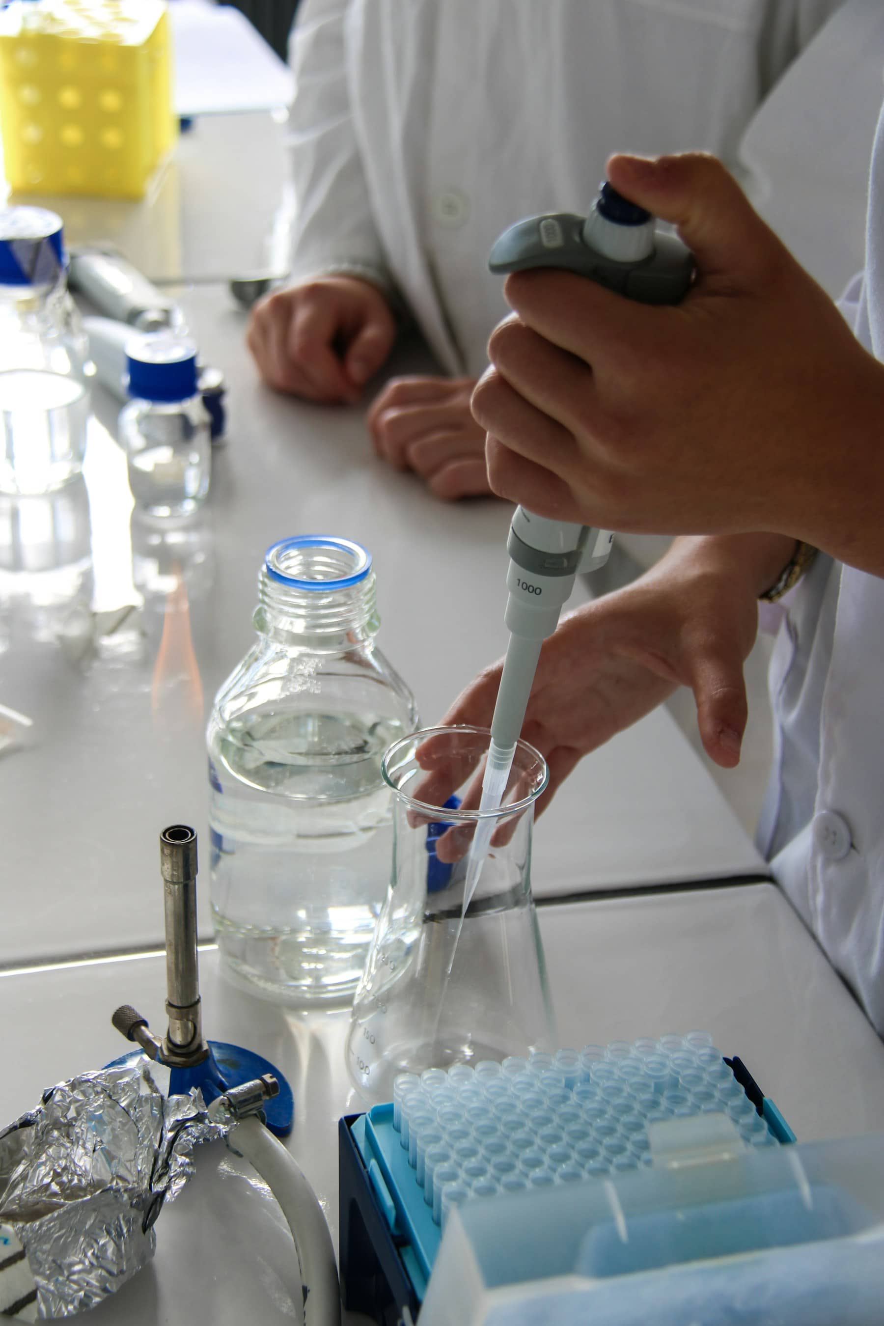 Profissional manipulando uma pipeta durante uma análise em laboratório.