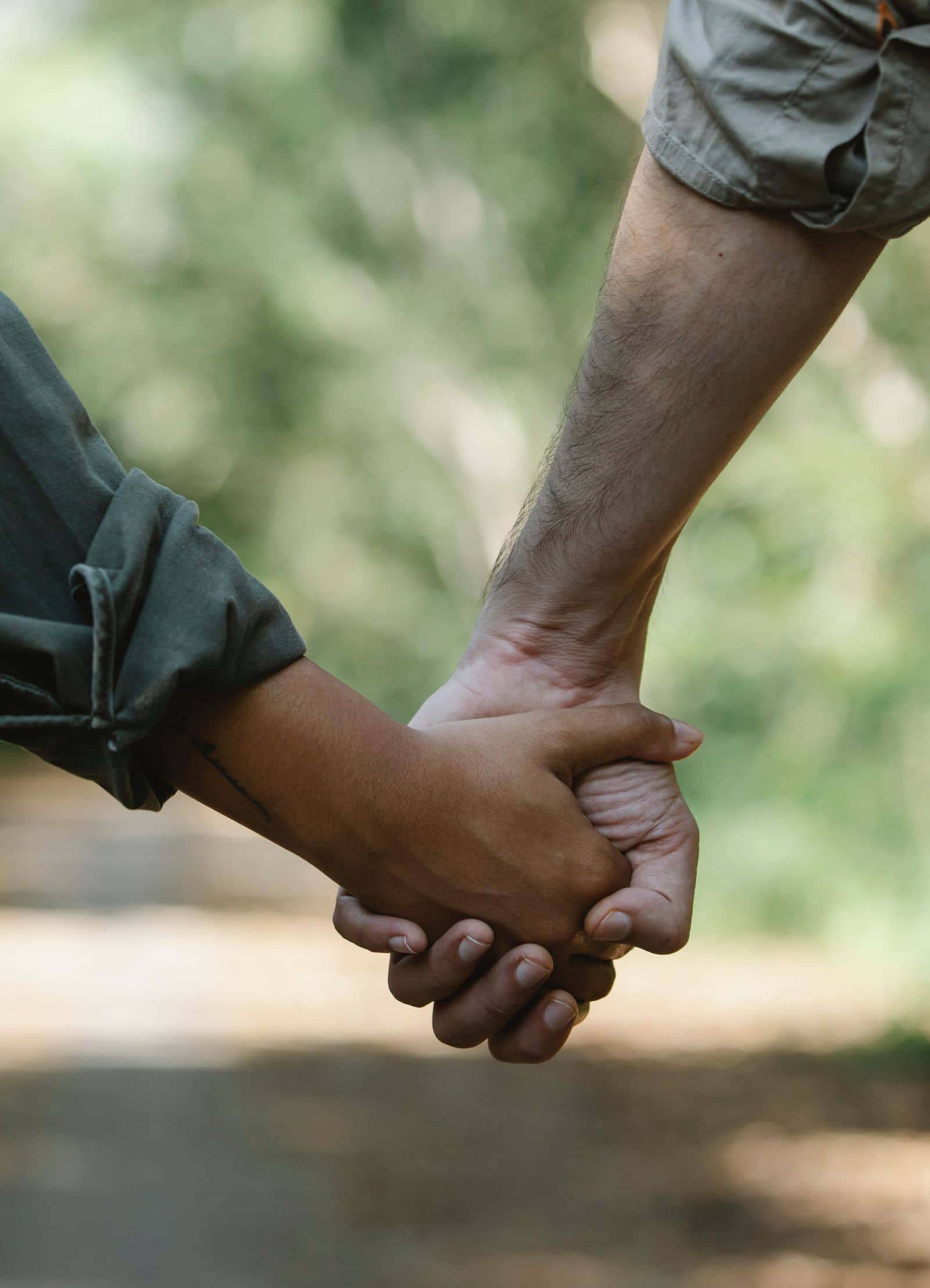 Duas pessoas de mãos dadas ao ar livre
