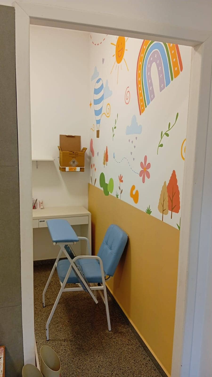 Sala de coleta infantil com painel ilustrado e cadeiras de coleta.